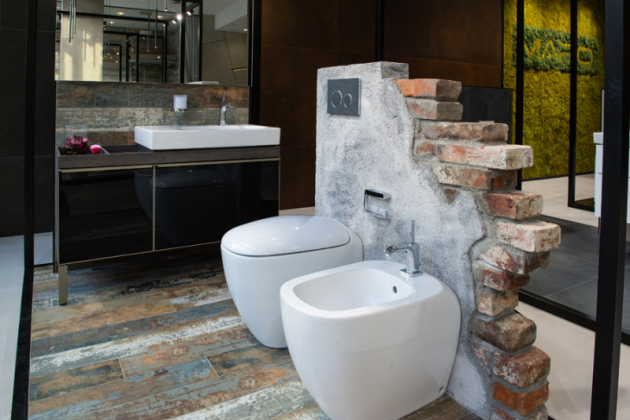 Syrový industriál  Design průmyslových továren evokuje koupelna, kde dekor dlažby připomíná oprýskaný lak na dřevěné podlaze, v kombinaci s ostrými hranami plechovkových detailů se skleněným povrchem u podumyvadlové skříňky Geberit, působí velmi industriálně. Vše je zjemněno oblými tvary sanitárních zařizovacích předmětů, které vyvažuje ovládací tlačítko Geberit z pravé břidlice.