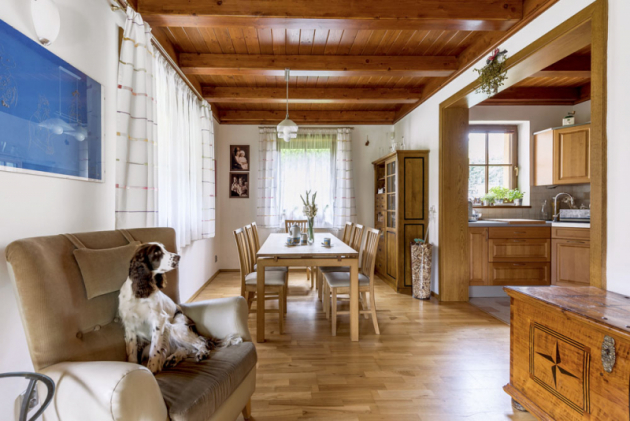 Obývací pokoj volně navazuje na jídelnu s kuchyní, jež jsou oproti němu laděné do dřeva