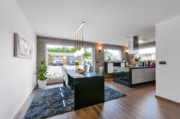 S betonovou stěrkou v obývacím pokoji zajímavě rezonuje skleněná posuvná příčka, která místnost dělí na dvě části zařízené s minimalistickým přístupem