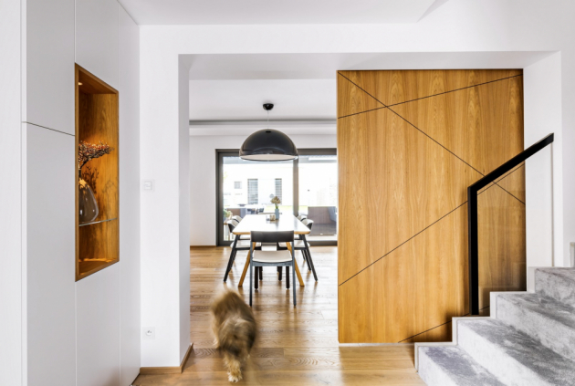 obývací pokoj Dominantním prvkem obýváku je posuvný dřevěný panel za sedačkou, který nahrazuje dveře z chodby do obytného přízemí 