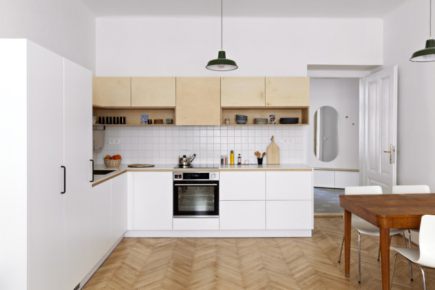 KUCHYŇSKÝ KOUT Součástí obytného prostoru je rohová kuchyň kombinující bílé plochy stříkané MDF desky a březovou překližku. Nabízí dostatečné úložné prostory i pracovní plochu