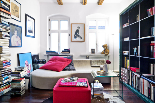 OBÝVACÍ POKOJ Velké množství knih dělá v bytě další zajímavou kulisu. K odpočinku je vždy připravené menší šedé sofa a červený taburet 