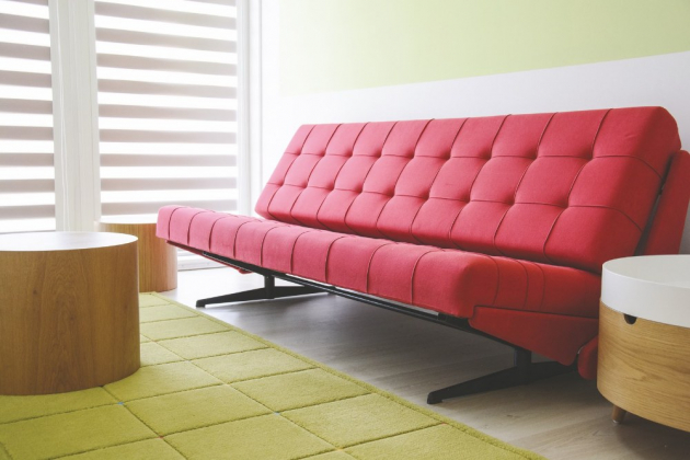 Červené doplňky jsou patrné v jídelně s velkým elegantním stolem a obývacím pokoji, jemuž dominuje kožená bordó sofa s nádechem funkcionalismu, na kterou jsou majitelé náležitě pyšní.