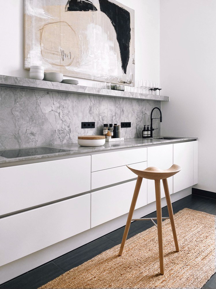 Použití mramoru navozuje luxusní dojem z jinak velmi jednoduché minimalistické kuchyně 