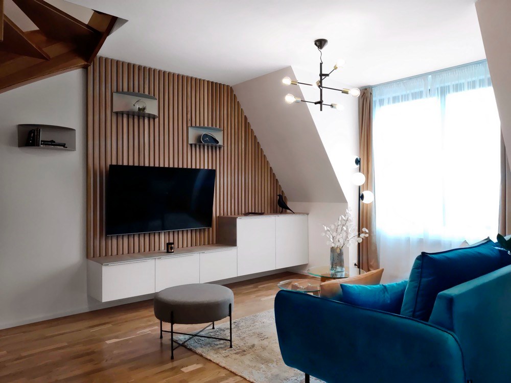 Výrazným designovým prvkem, který najdete na několika místech bytu, jsou dubové lišty – zde použité jako základ pro TV stěnu