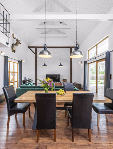 Obývací část s vysokým dřevěným stropem je propojena s kuchyní, kde naleznete veškeré potřebné vybavení