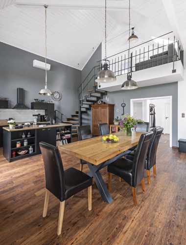 Obývací část s vysokým dřevěným stropem je propojena s kuchyní, kde naleznete veškeré potřebné vybavení