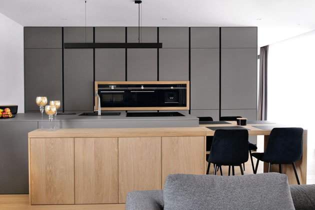 Sestava z materiálu NaNoTeQ, šedý základ oživují černé spáry, doplňky a ostrůvek s dekorem světlého dřeva