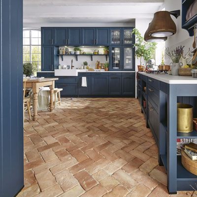 Kuchyň Finca, venkovsky laděný styl podtrhuje výraznější barevné provedení tlumené bílými doplňky a cihlovou podlahou