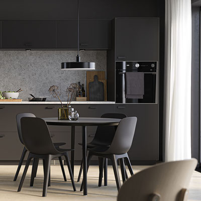 Sestava Nickebo, černé matné plochy nábytku s tmavými úchyty decentně oživuje světlejší šedá plocha nad pracovní plochou s jemným dekorem