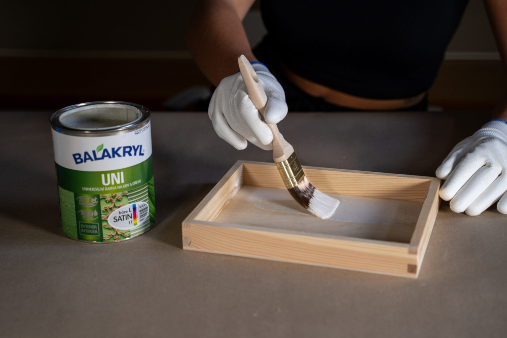 Co budete potřebovat? Na v&yacute;robu budete potřebovat libovoln&yacute; dřevěn&yacute; podnos, skleněn&eacute; mozaikov&eacute; střepy nebo kam&iacute;nky (k dost&aacute;n&iacute; v obchodech s v&yacute;tvarn&yacute;mi potřebami), lepidlo na mozaiku, jemnou brusnou houbu, ploch&yacute; &scaron;tětec (vel. 1,5&ldquo;), tenk&yacute; v&yacute;tvarn&yacute; &scaron;tětec, ochrann&eacute; rukavice a vodou ředitelnou barvu Balakryl UNI satin.  N&Aacute;&Scaron; TIP: Kryc&iacute; n&aacute;těr Balakryl UNI satin je určen k venkovn&iacute;m i vnitřn&iacute;m n&aacute;těrům dřeva a dal&scaron;&iacute;ch materi&aacute;lů. Snadno se rozt&iacute;r&aacute;, v&yacute;borně kryje a rychle schne. Povrchům dod&aacute; kr&aacute;sně hladk&yacute; sat&eacute;nov&yacute; vzhled a chr&aacute;n&iacute; je před povětrnostn&iacute;mi vlivy. Nav&iacute;c m&aacute; atest pro styk s potravinami a na dětsk&eacute; hračky. Do v&yacute;roby se tak může zapojit cel&aacute; rodina. Začněte nov&yacute;m odst&iacute;nem Dřevěn&yacute; podnos nejdř&iacute;ve jemně zbruste a pot&eacute; omeťte od prachu. Povrch mus&iacute; b&yacute;t tak&eacute; zbaven v&scaron;ech nečistot, mastnoty a př&iacute;padn&yacute;ch star&yacute;ch nepřilnav&yacute;ch n&aacute;těrů. Kryc&iacute; barvu před použit&iacute;m důkladně prom&iacute;chejte. Nan&aacute;&scaron;ejte ji ploch&yacute;m &scaron;tětcem ve 2 vrstv&aacute;ch s odstupem alespoň 2 hodiny.  Mozaika jako uměleck&eacute; d&iacute;lo Pak přich&aacute;z&iacute; na řadu sestaven&iacute; mozaiky. Skleněn&eacute; střepy doporučujeme na podnos nejdř&iacute;ve cvičně vyskl&aacute;dat tak, aby zab&iacute;raly celou plochu a nikde nezůstala velk&aacute; mezera. Nezapomeňte si tak&eacute; rozvrhnout barevn&eacute; kombinace, př&iacute;padně motiv. Jakmile budete s v&yacute;sledkem spokojeni, zafixujte postupně v&scaron;echny střepy pomoc&iacute; tenk&eacute;ho &scaron;tětečku a lepidla.  N&Aacute;&Scaron; TIP: Po zaschnut&iacute; lze na mozaiku nan&eacute;st je&scaron;tě tenkou vrstvu sp&aacute;rovac&iacute; hmoty &ndash; ta vypln&iacute; mezery a povrch sjednot&iacute;. Pokud v&aacute;m ale vyhovuje hrub&scaron;&iacute;, rustik&aacute;lněj&scaron;&iacute; vzhled, tento krok můžete vynechat. Na stůl nebo na zeď? Je v&aacute;m l&iacute;to na takov&yacute; pěkn&yacute; podnos serv&iacute;rovat? Pověste ho na stěnu jako obraz! Vlastnoručně vyroben&aacute; barevn&aacute; mozaika zaručeně rozvesel&iacute; va&scaron;i pracovnu, j&iacute;delnu nebo třeba dětsk&yacute; pokoj.