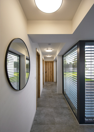 D&iacute;ky velk&yacute;m prosklen&yacute;m ploch&aacute;m je dům velkoryse prosvětlen. V&nbsp;l&eacute;tě před přehř&iacute;v&aacute;n&iacute;m chr&aacute;n&iacute; interi&eacute;r předokenn&iacute; žaluzie